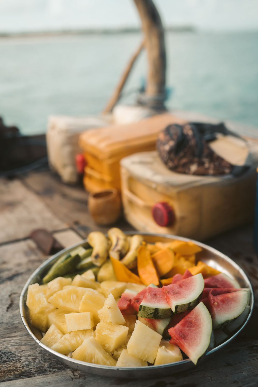 Sliced tropical fruits on a plate by the seaside